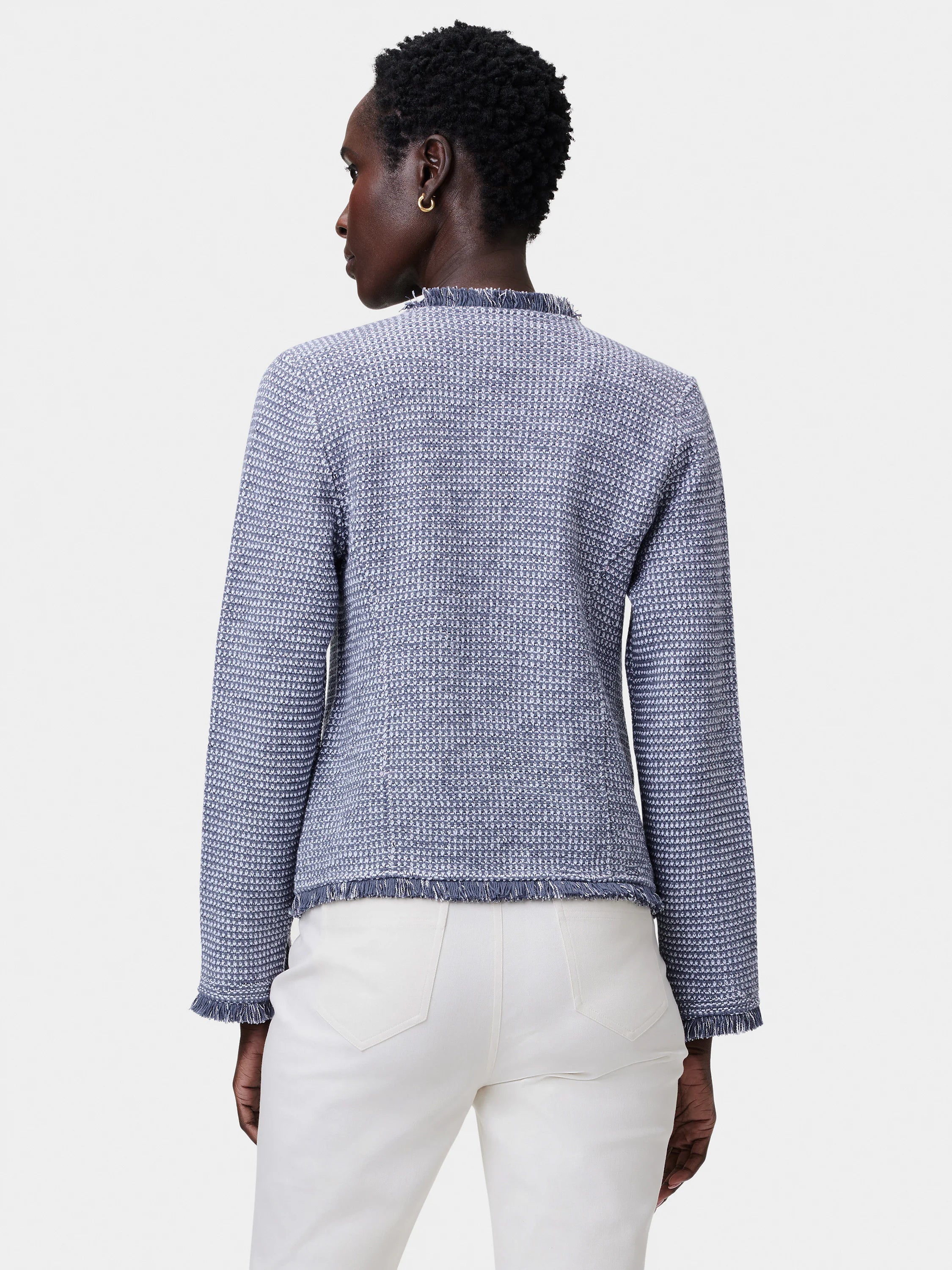 Blue & white mixed knit jacket with fringe trim at collar, hem, & cuffs, worn by a model from behind.