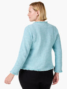 Aqua mix knit jacket with fringe trim at the collar, hem, and cuffs. Model wears it from the back.