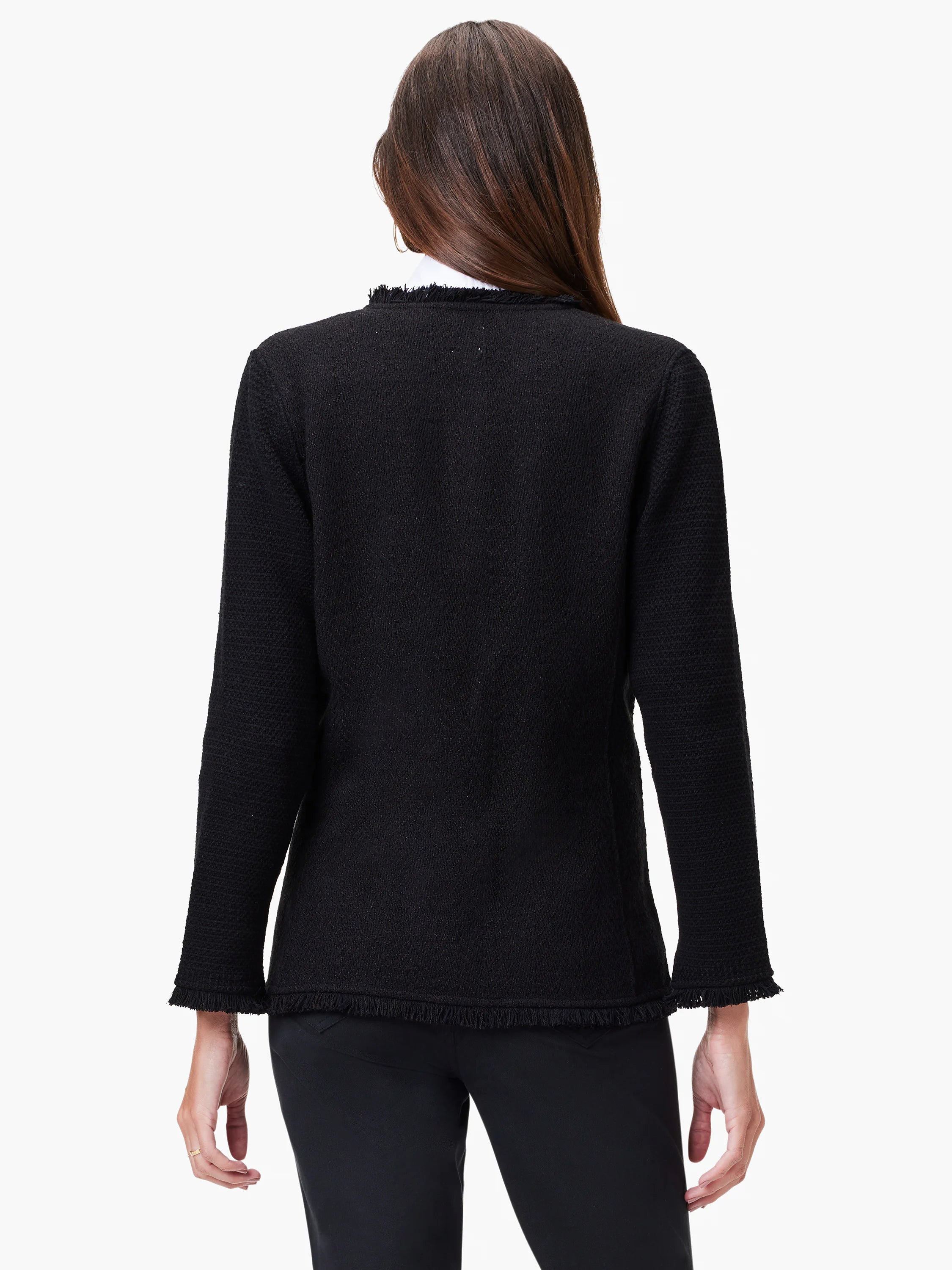 Black knit jacket, long sleeves, textured fabric, fringe trim at hem and cuffs. Rear view.