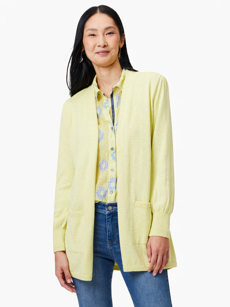 Pale yellow open cardigan with long sleeves and two pockets. Shown on a model.