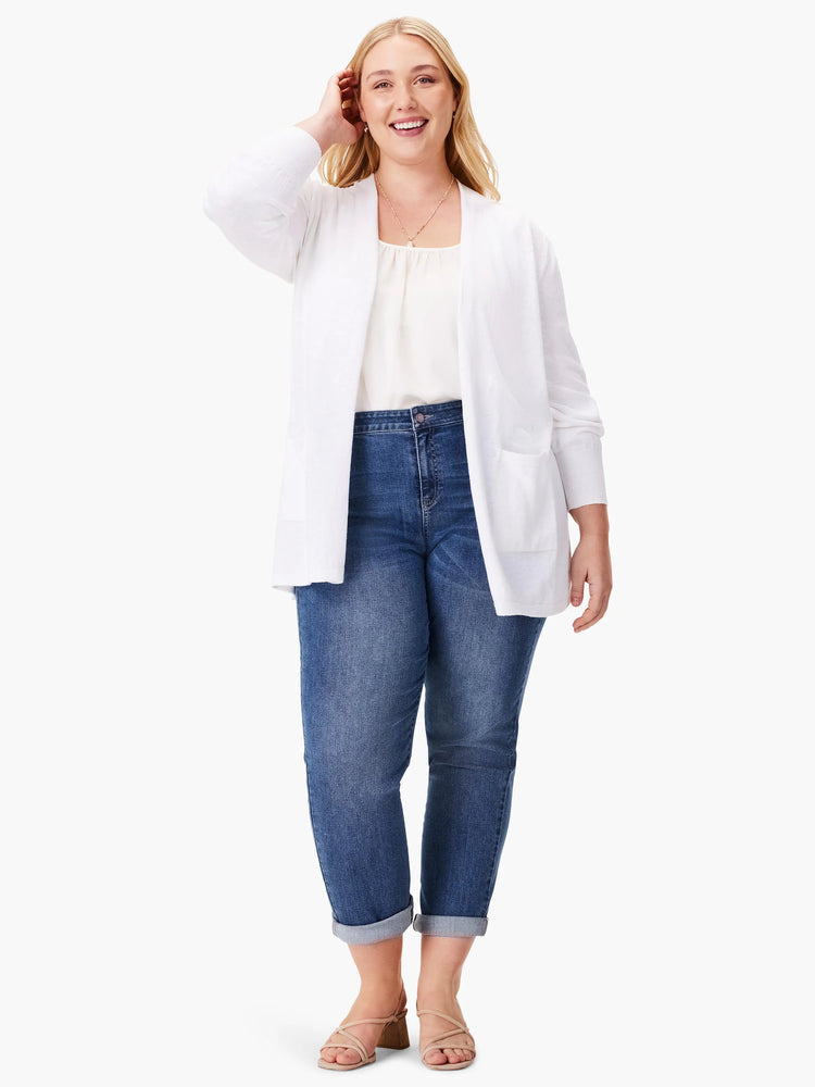 White open cardigan, pockets. Model wears blue jeans and light brown sandals.
