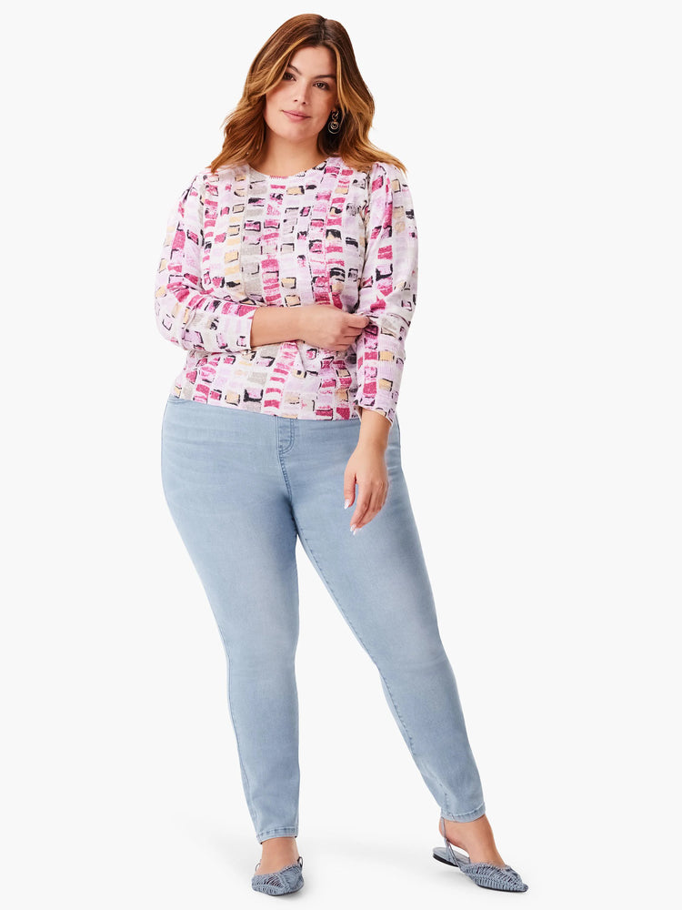 White sweater with pink, gray, and beige geometric mosaic pattern. Long sleeves.