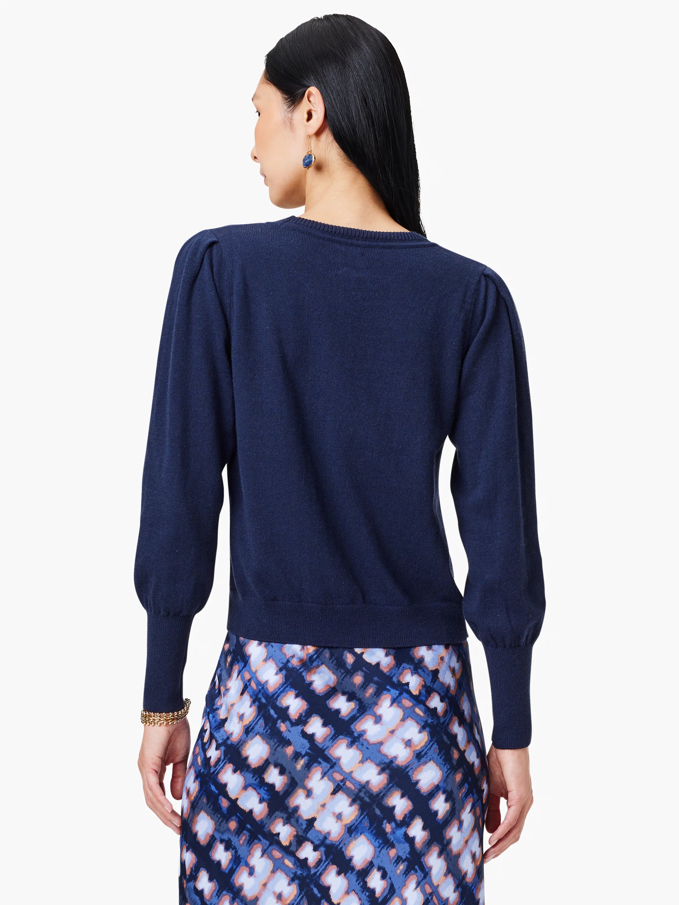 Navy blue round-neck sweater, back view, with puff sleeves gathered at the cuffs, worn by a model.