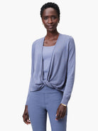 Periwinkle blue cardigan, tied in a front knot over a matching top. Features long sleeves and an open front.