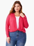 Bright pink knit cardigan with ribbed cuffs, tied in a front knot.