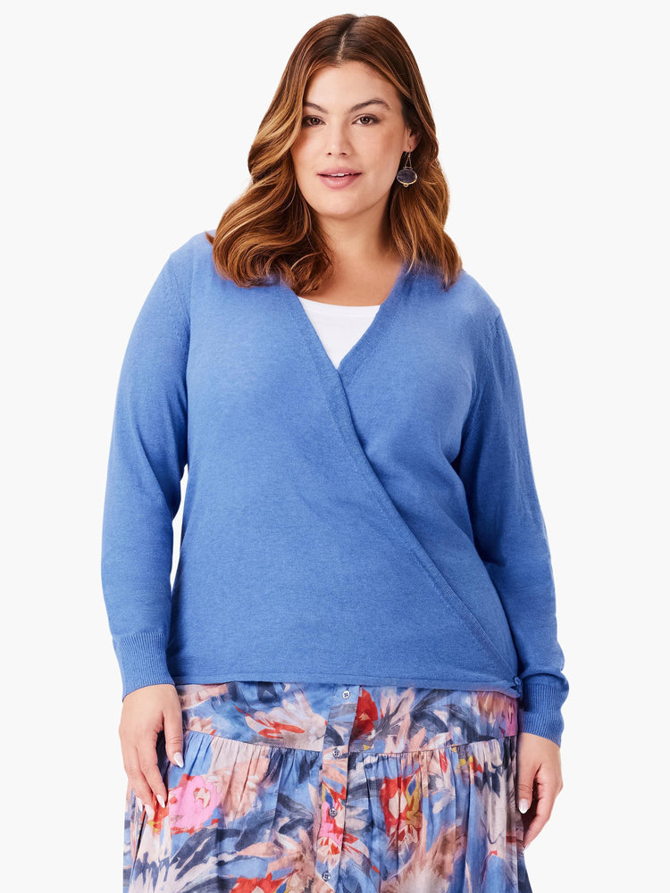 Blue long-sleeve cardigan with a crossover V-neck front, worn over a white top.