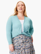 Light blue open-front cardigan with long sleeves and ribbed cuffs, tied at the waist over a white top.