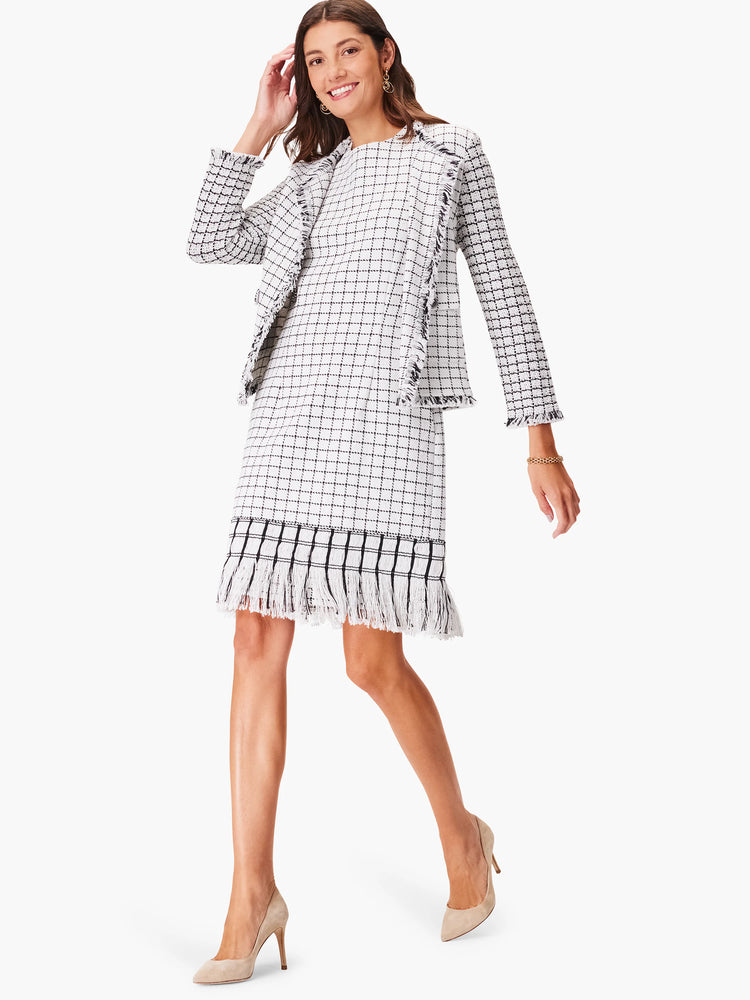 White & black grid pattern dress with fringe trim at hem and jacket.
