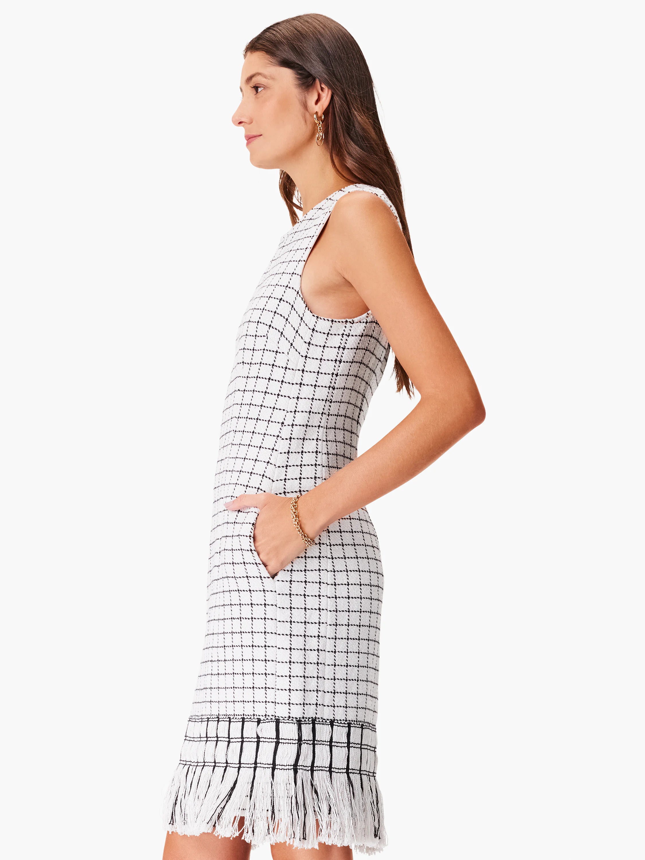 White sleeveless dress with black grid pattern and black fringe trim.