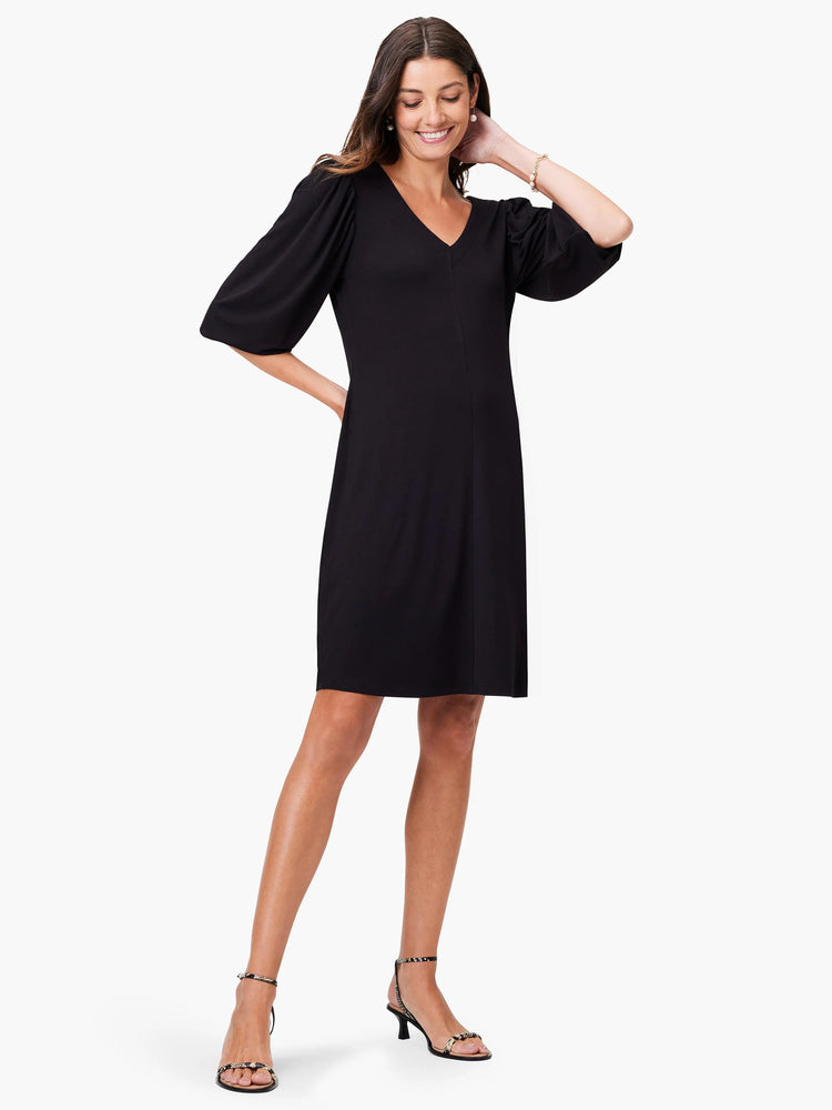 Black V-neck knit dress, short sleeves with slight puff, knee-length.