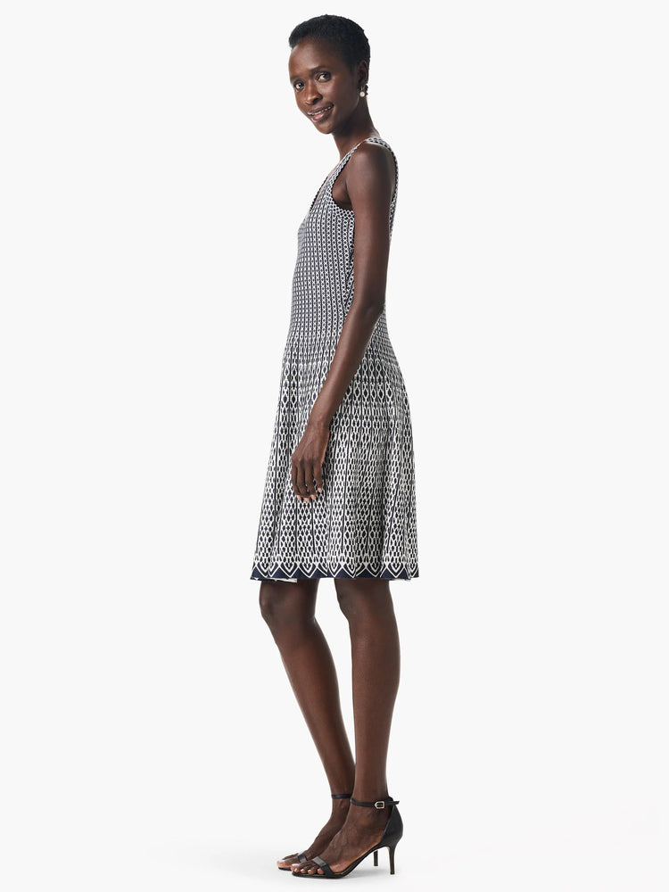 Sleeveless, knee-length dress. Navy and off-white geometric pattern. Fitted bodice, flared skirt.