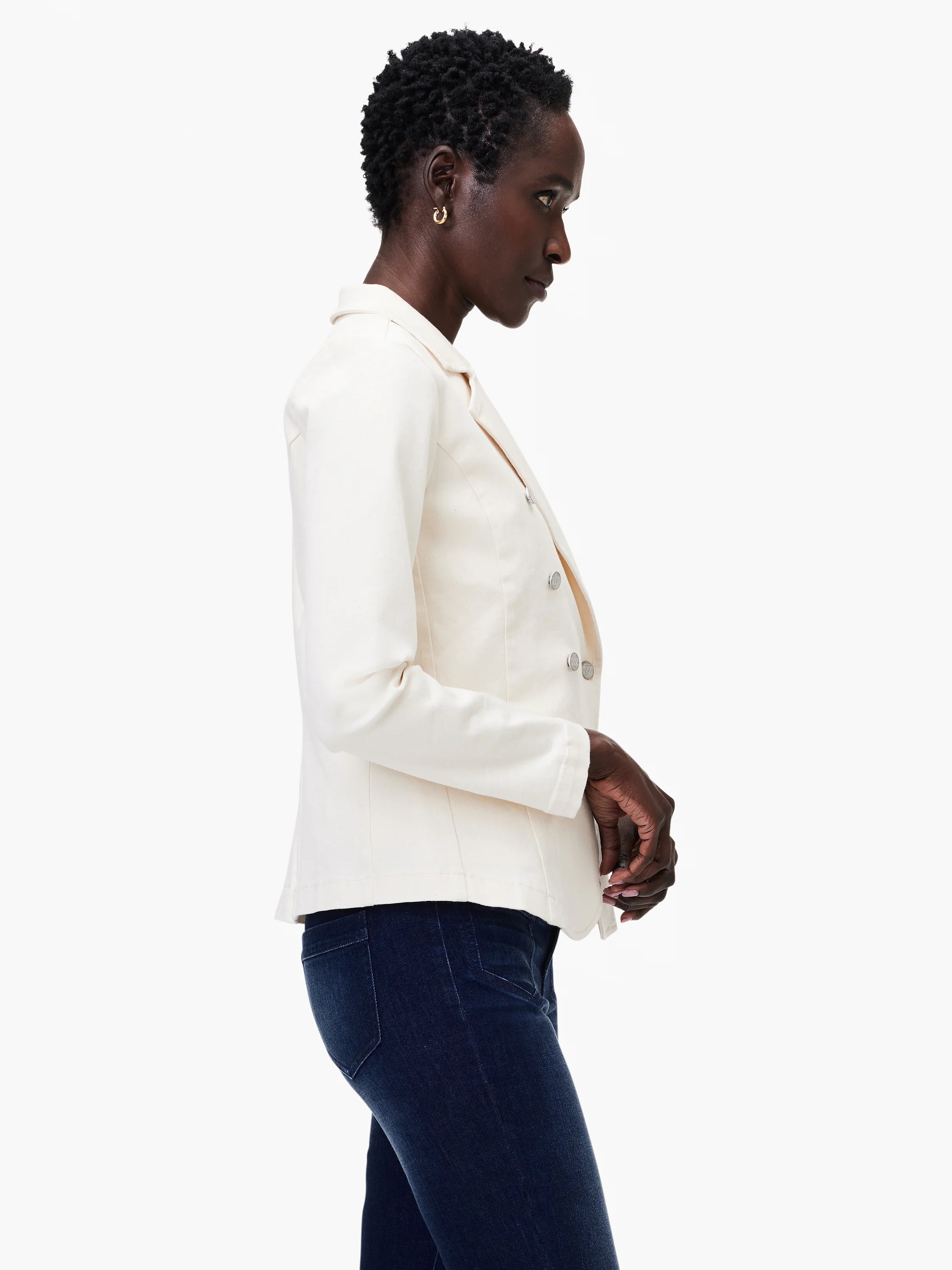 Off-white denim blazer, double-breasted, with silver buttons. Model wears dark wash jeans.