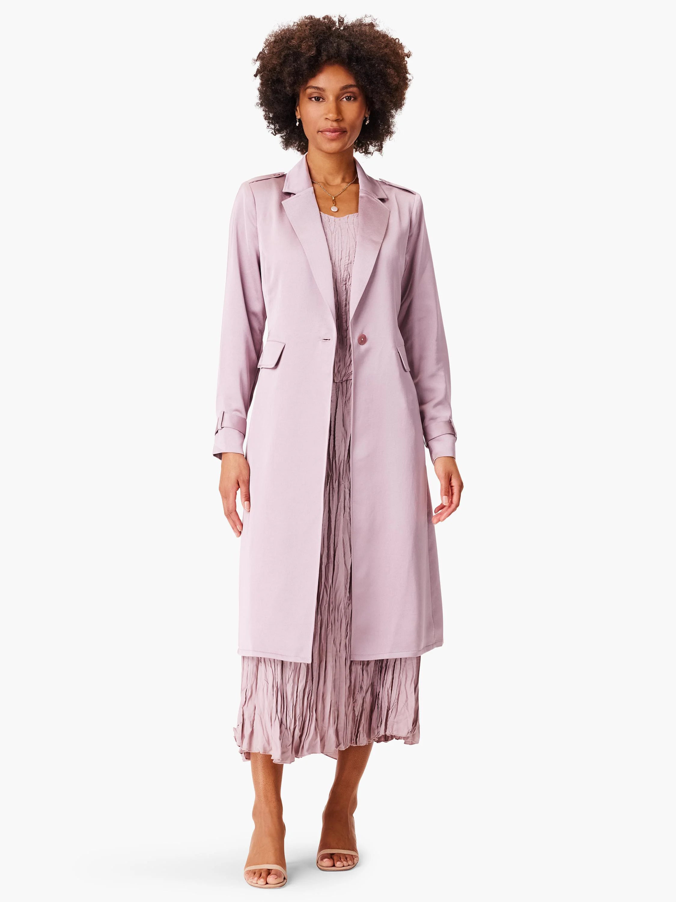 Lilac trench coat, knee-length, single button closure, long sleeves with tab detail. Model shown wearing with pleated...