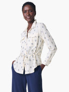 Off-white shirt jacket with navy blue geometric pattern, cinched waist, and long sleeves.