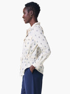 Off-white shirt jacket with navy blue geometric pattern, long sleeves, and drawstring waist.