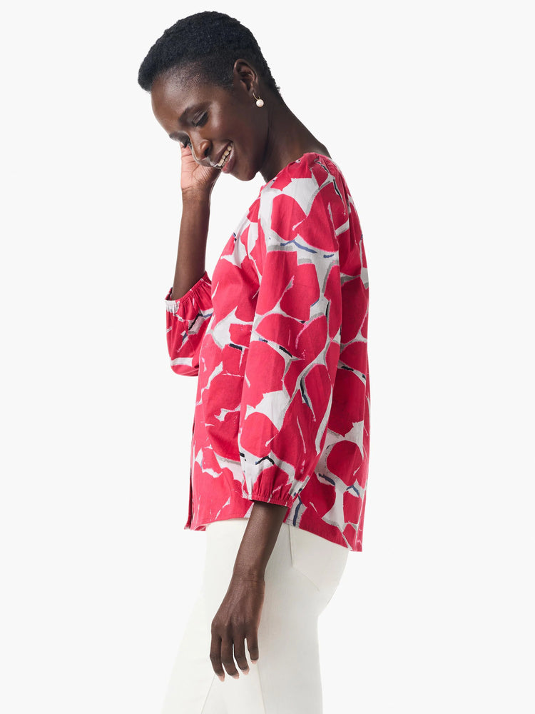Pink shirt with an abstract, bold floral print in grey and white. Three-quarter sleeves.