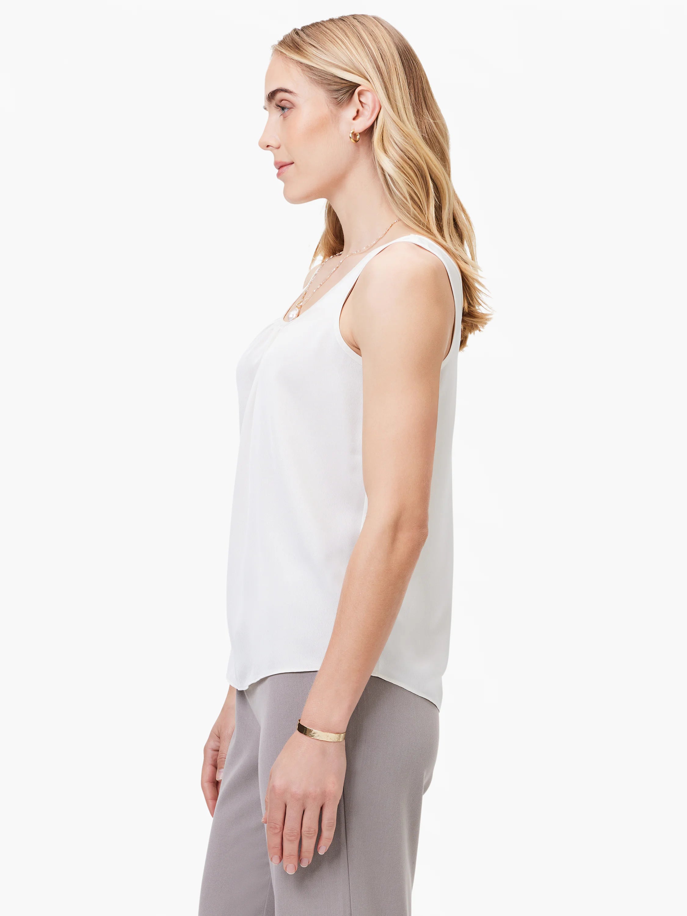 Cream sleeveless scoop neck tank with soft draping at the neckline.