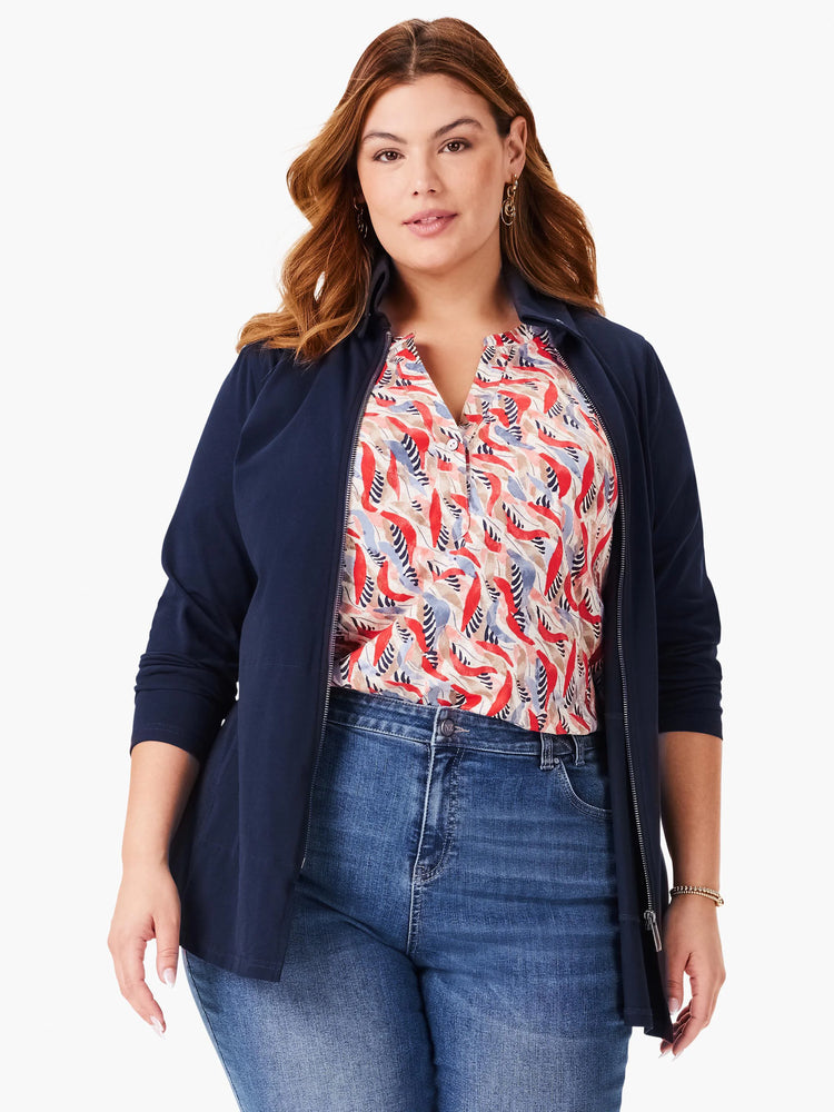 Navy blue zip-up jacket. Features a collar and long sleeves. Model also wears a cream, red, and blue patterned shirt...
