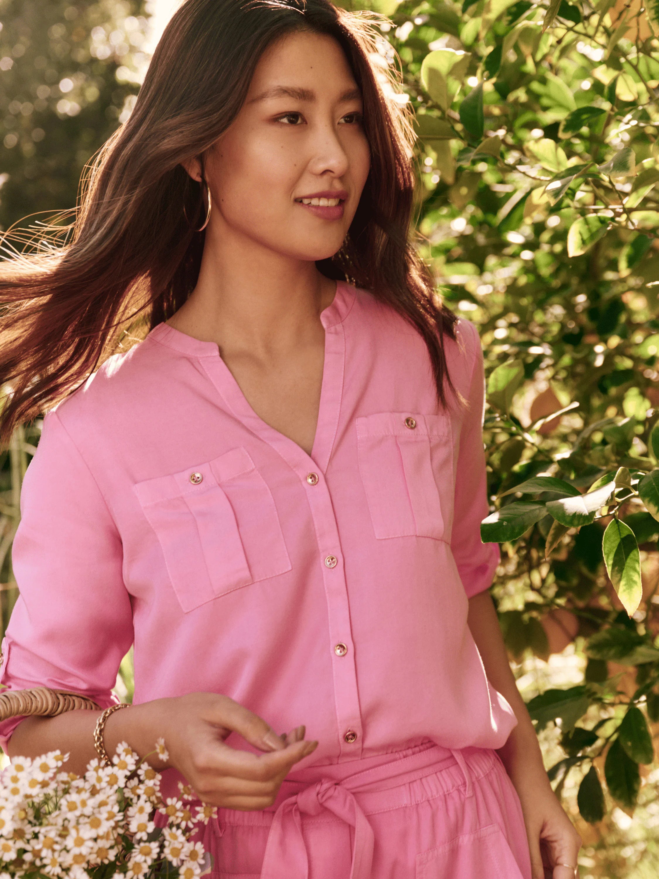 Pink button-down shirt; three-quarter sleeves, two chest pockets, gold buttons. Model shown wearing matching pink pants.