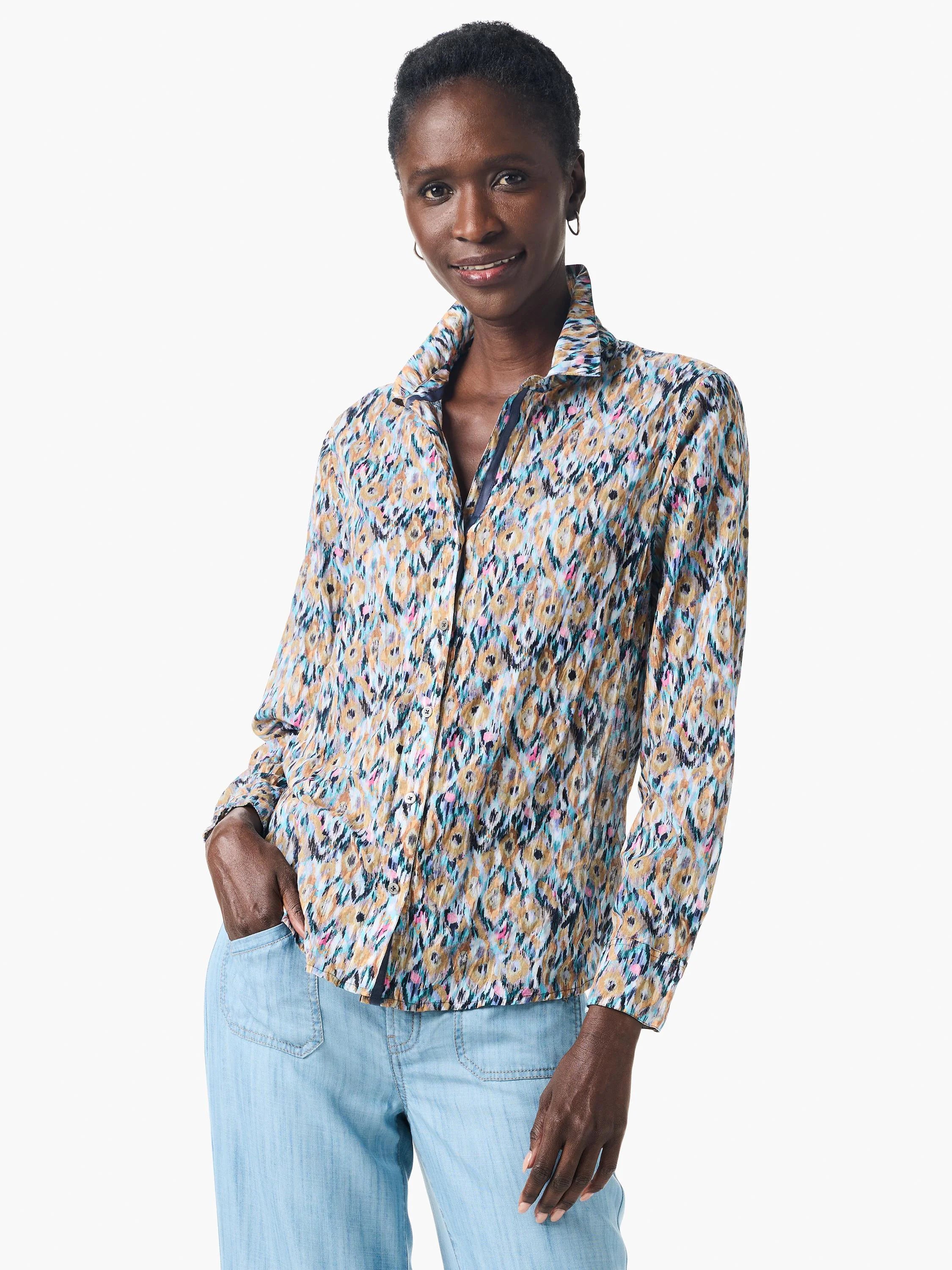 Long-sleeve button-down shirt in beige, teal, pink, and black abstract print. Crinkled fabric.