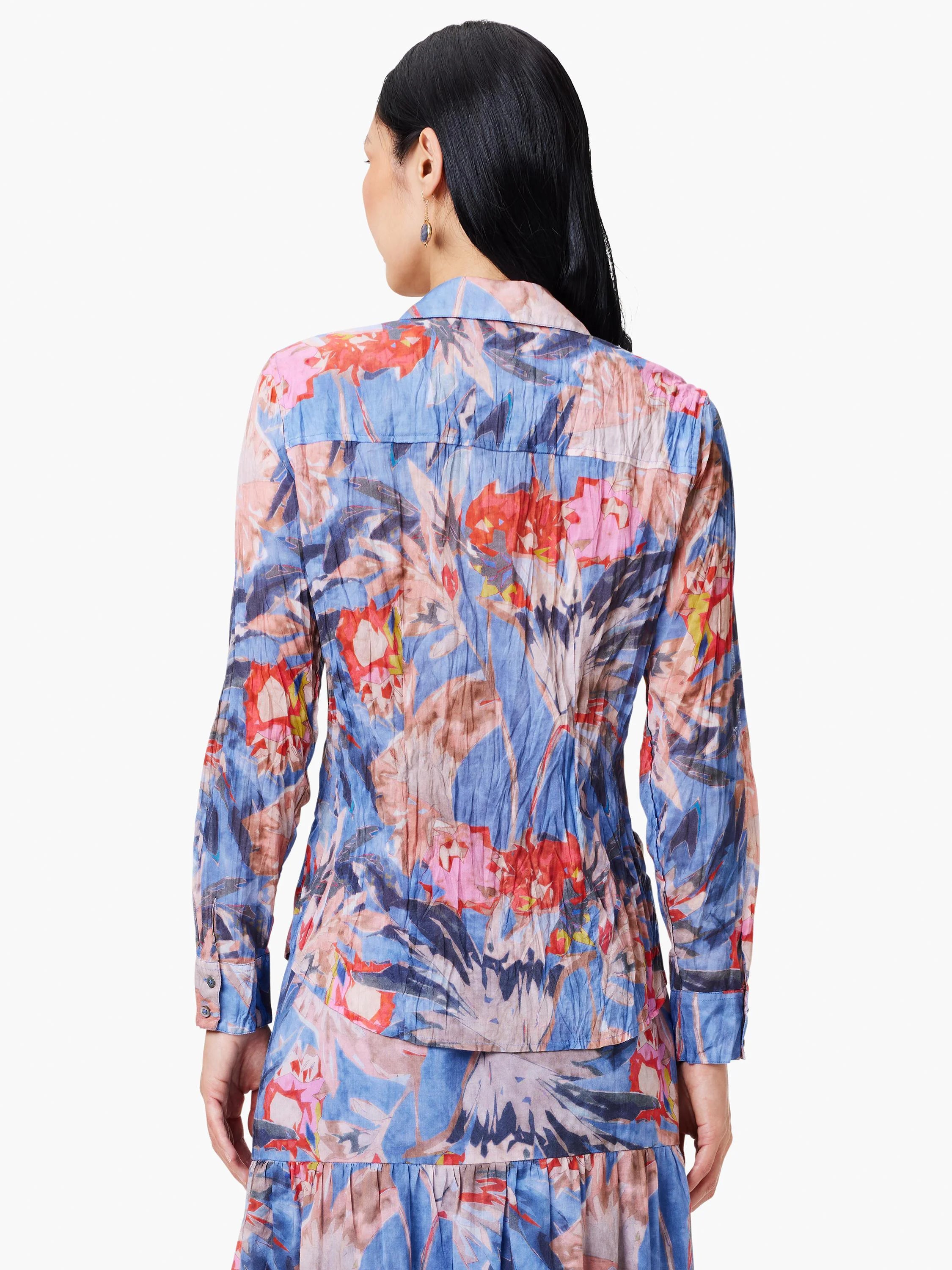 Blue shirt with red, pink & peach abstract floral print. Long sleeves, collared. Crinkled texture.