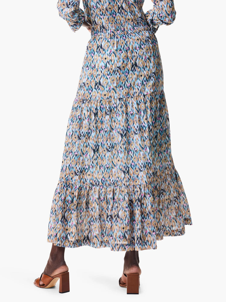Tiered maxi skirt in blue, tan, and black ikat print. Features multiple ruffles.