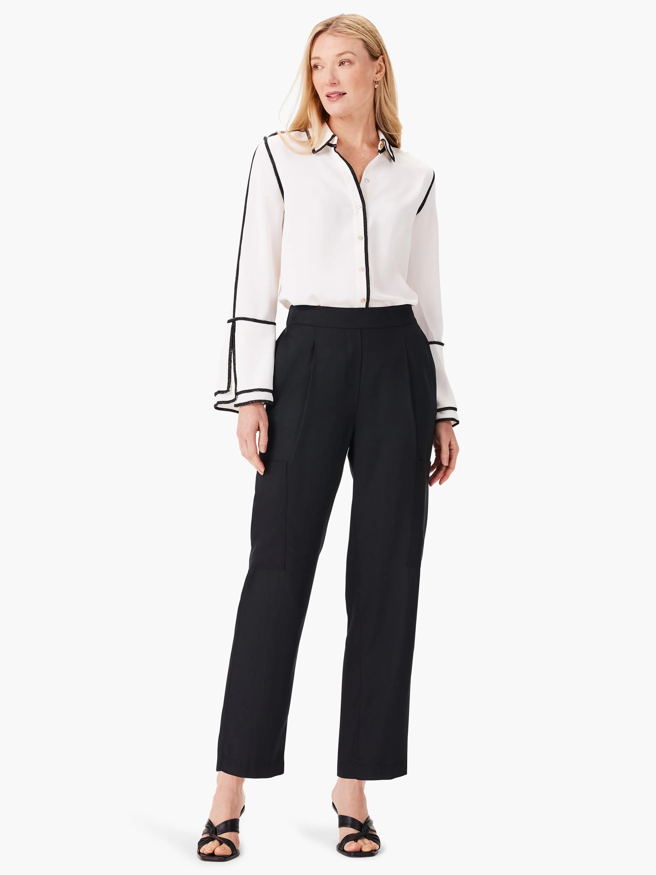 Black relaxed-fit cargo pants shown on a model. Features include pleats and patch pockets. The model also wears a white...
