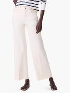 Cream wide leg jeans. Features a high waist, front pockets, and a frayed hem.