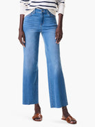 Mid-wash blue wide leg jeans, high-waisted, with a cropped length and frayed raw hem.