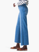 Cropped, medium blue wide-leg jeans feature a raw, frayed hem.