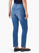 Medium blue mid-rise straight jeans seen from behind, showing back patch pockets, belt loops, and cropped length.