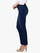 Dark blue mid-rise straight leg jeans, side view on a model, showing back pocket stitching.