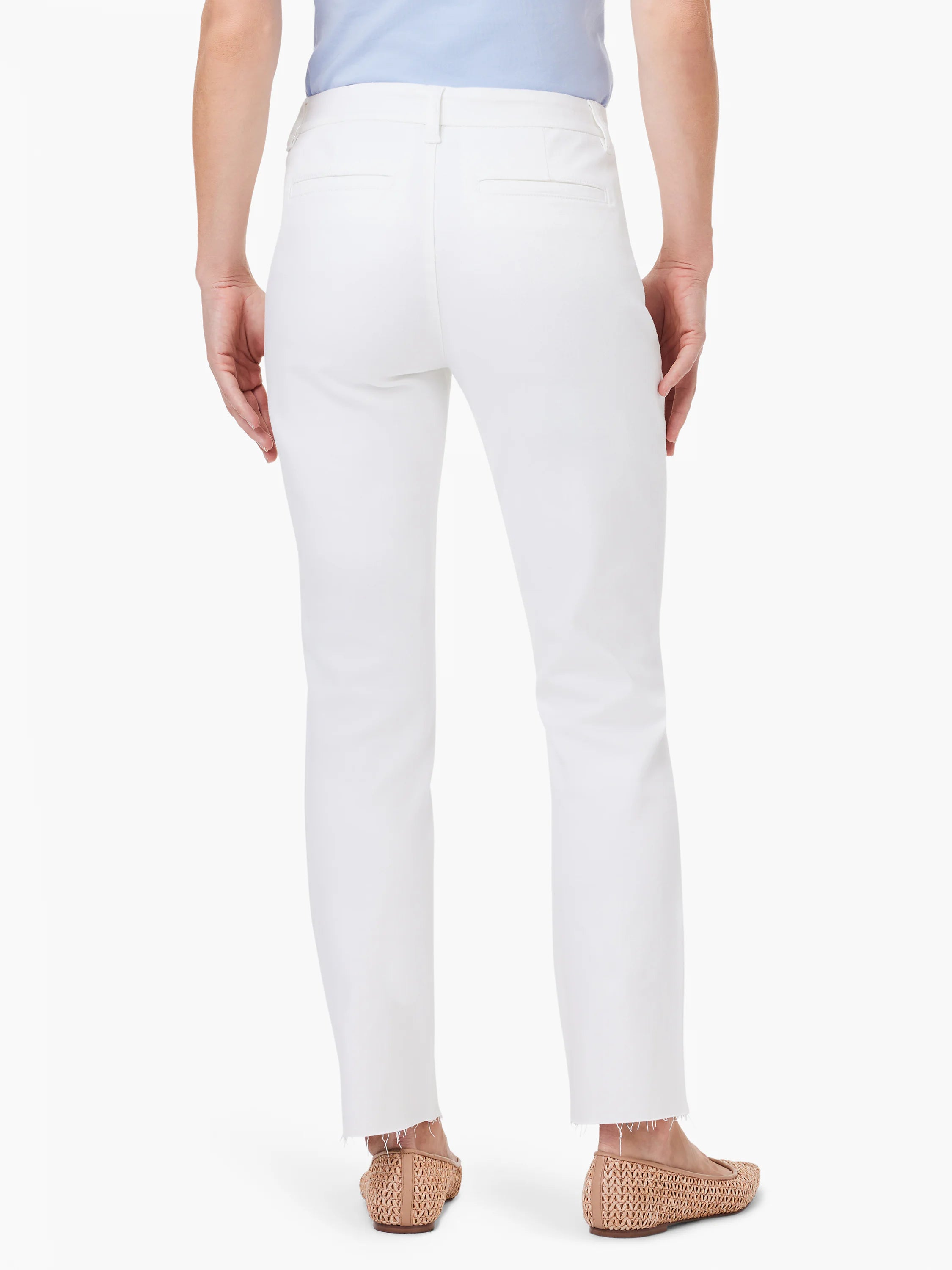 White straight ankle trousers with back welt pockets and a raw, frayed hem, shown from behind.