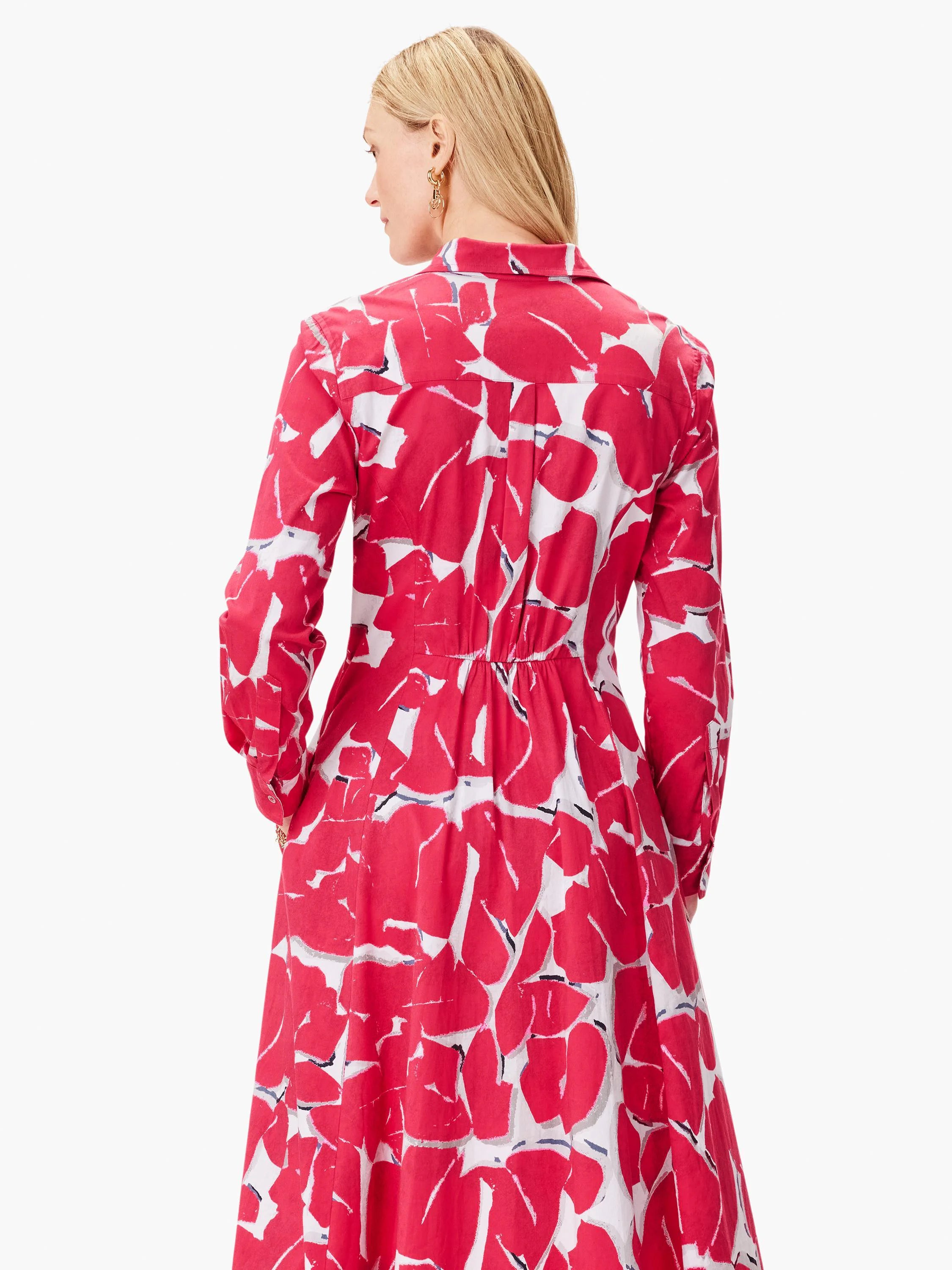 Pink dress with an abstract print featuring larger pink shapes on a white background. Long sleeves, collared shirt dress.
