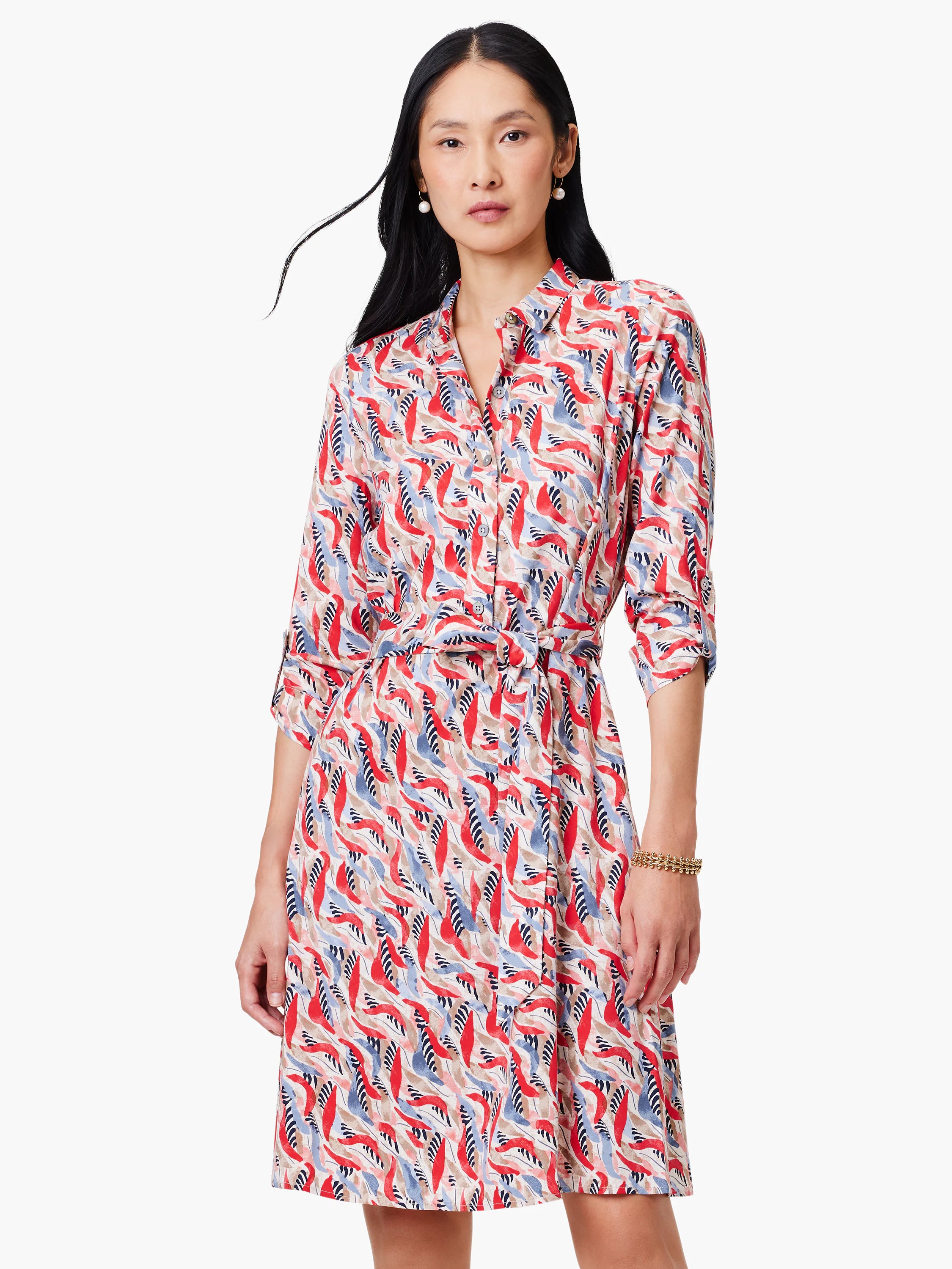 Shirt dress with red, blue, and beige abstract print. Belted waist, three-quarter sleeves.