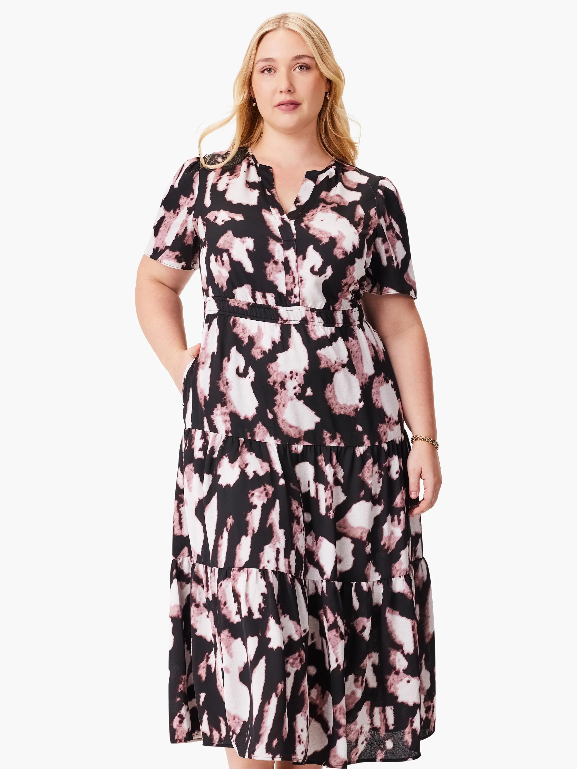 Midi dress, black background with mauve and white abstract print. Short sleeves, V-neck, tiered skirt, and pockets.