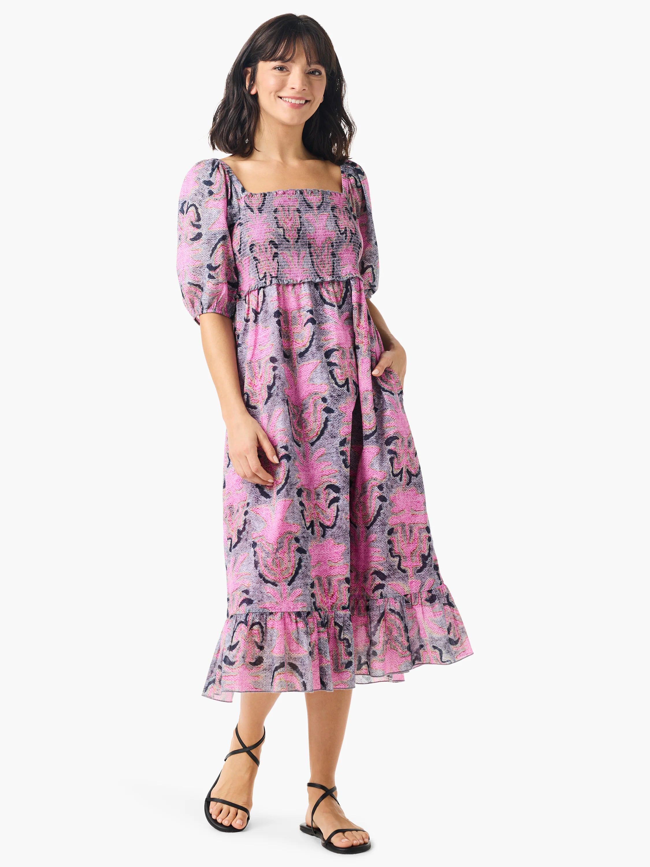 Pink and gray floral midi dress with short puff sleeves, square neckline, smocked bodice, and ruffled hem. Has pockets.