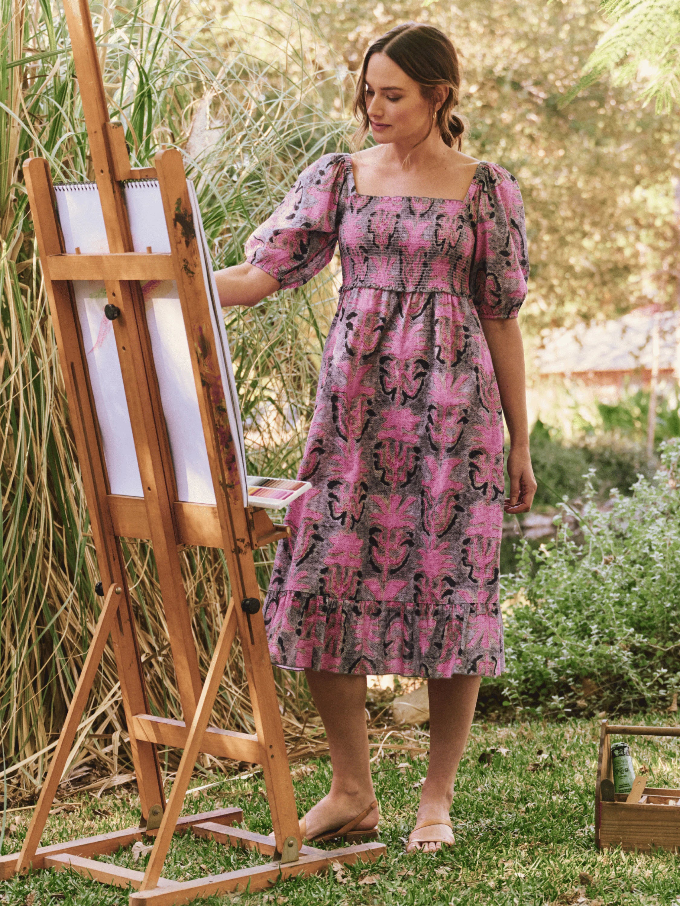 Pink and gray floral midi dress with puff sleeves and a smocked bodice. Features a ruffled hem.