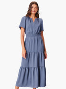 Dusty blue maxi dress with short sleeves, V-neck, elasticated waist, and tiered skirt.