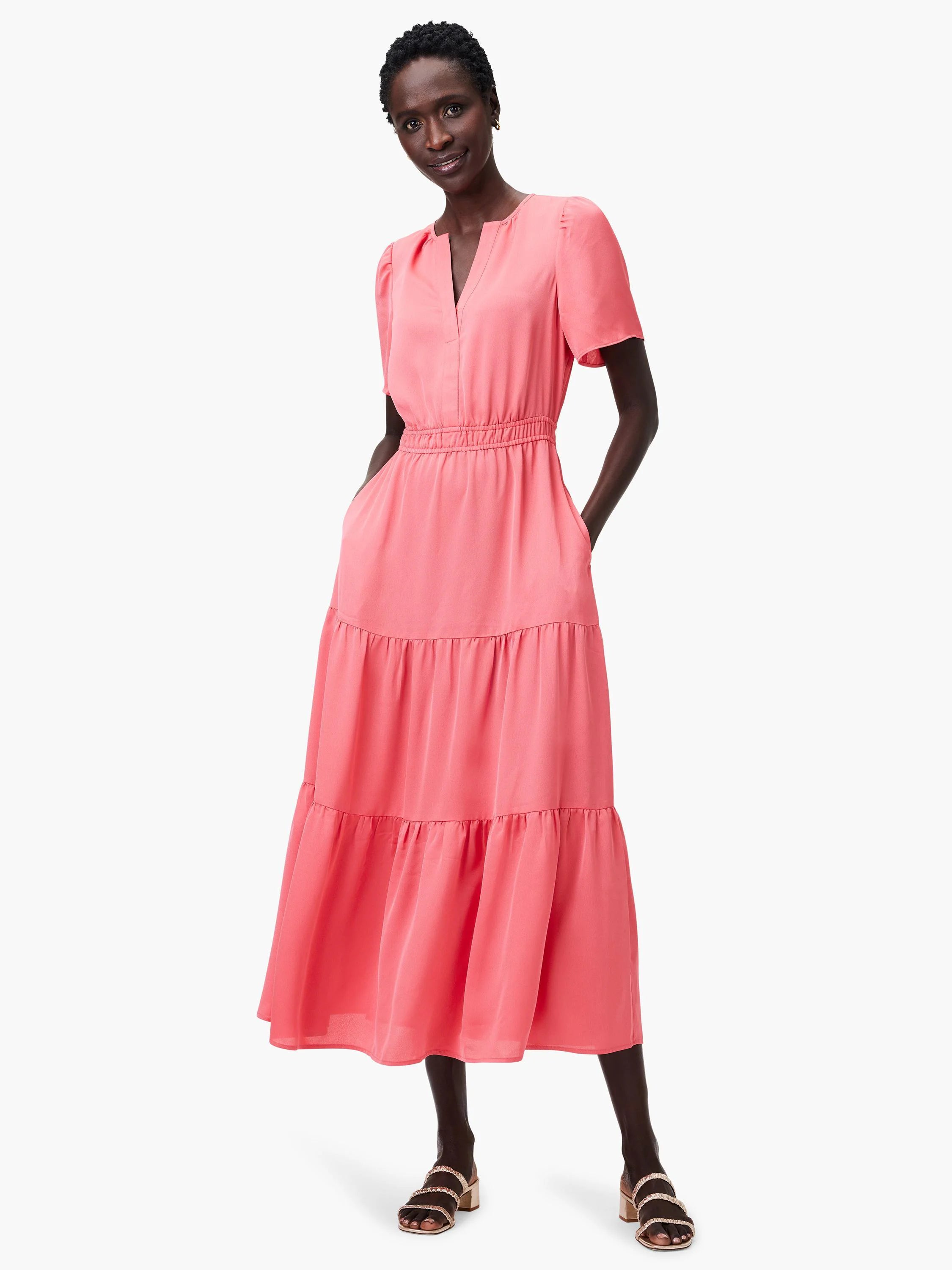 Coral pink tiered midi dress with V-neck, short puff sleeves, elastic waist, and pockets.