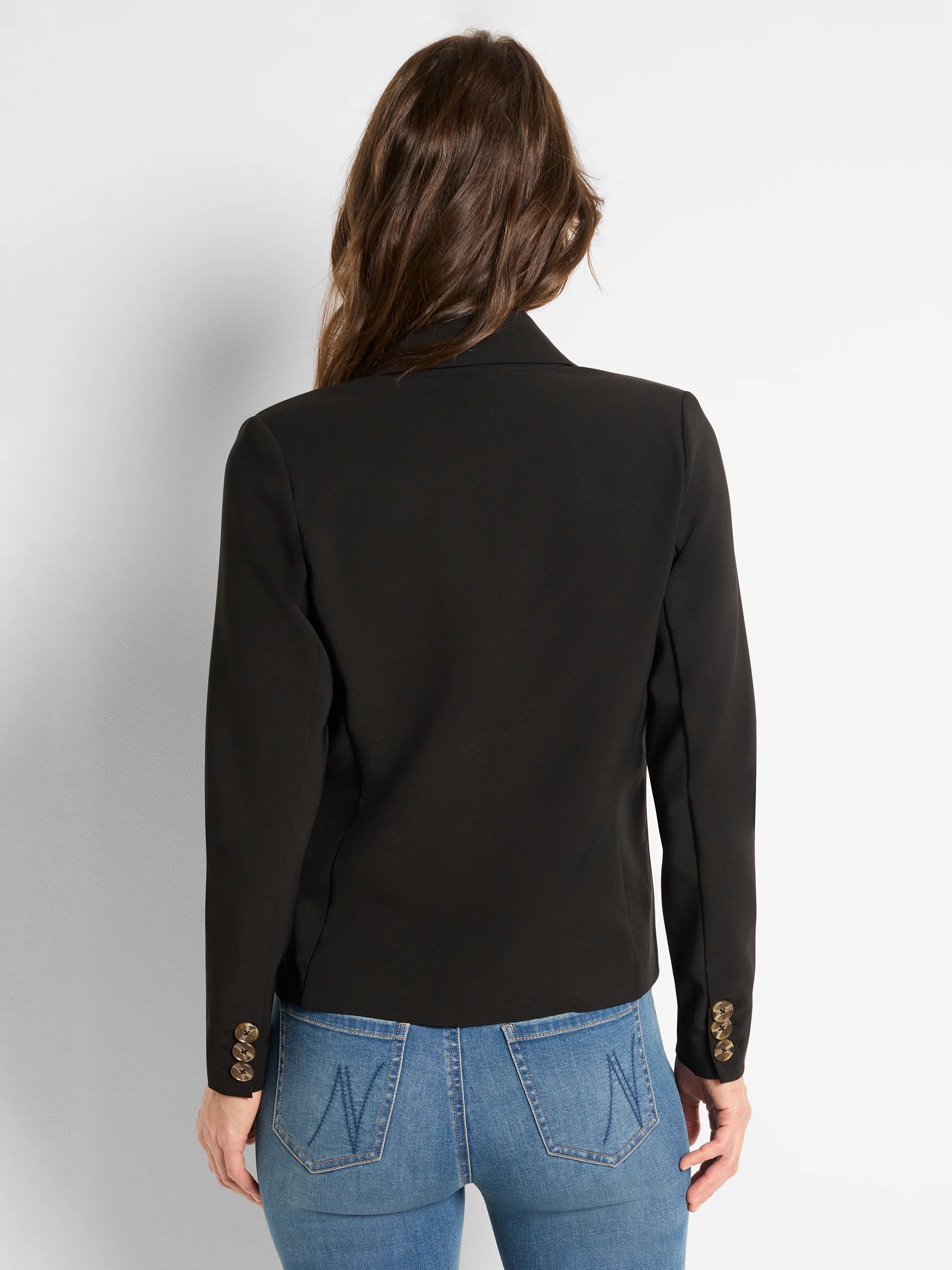 Black blazer, viewed from the back. Three light brown buttons are visible on each sleeve cuff.