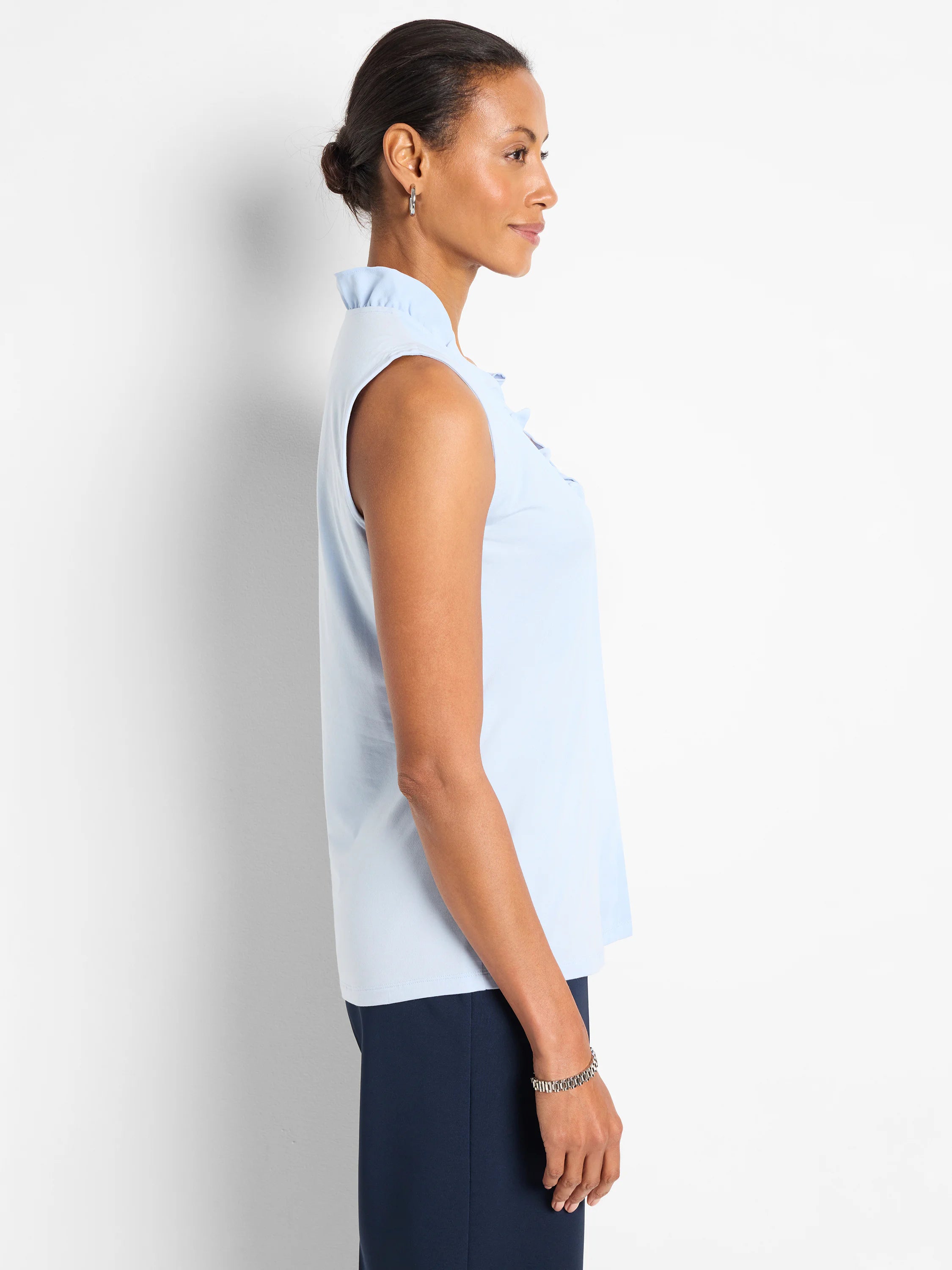 Light blue sleeveless tank with a ruffled stand collar and ruffles down the front placket.