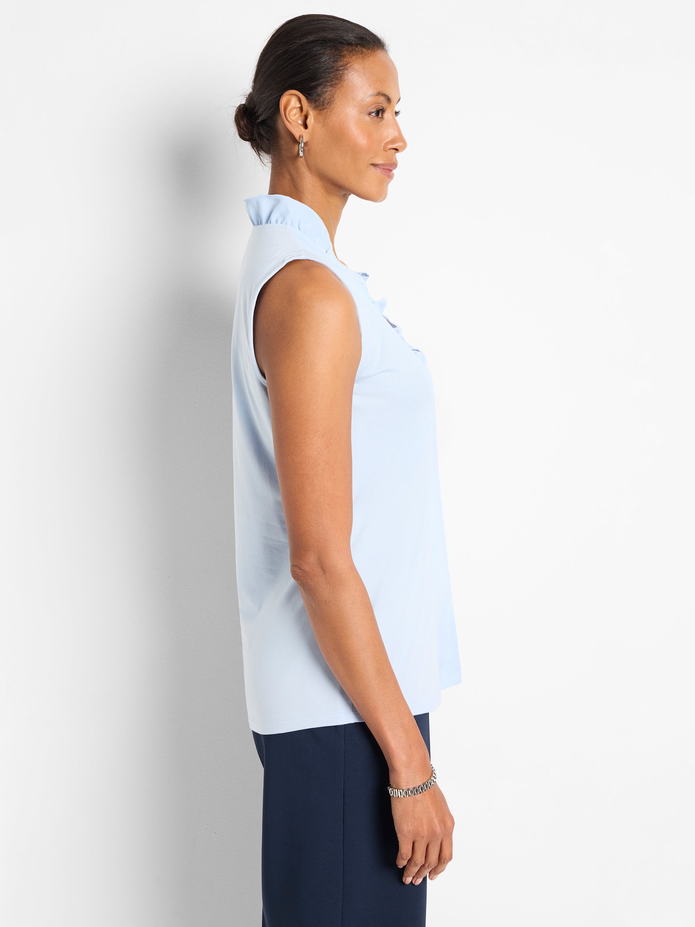 Light blue relaxed fit sleeveless top with a high ruffled neckline.