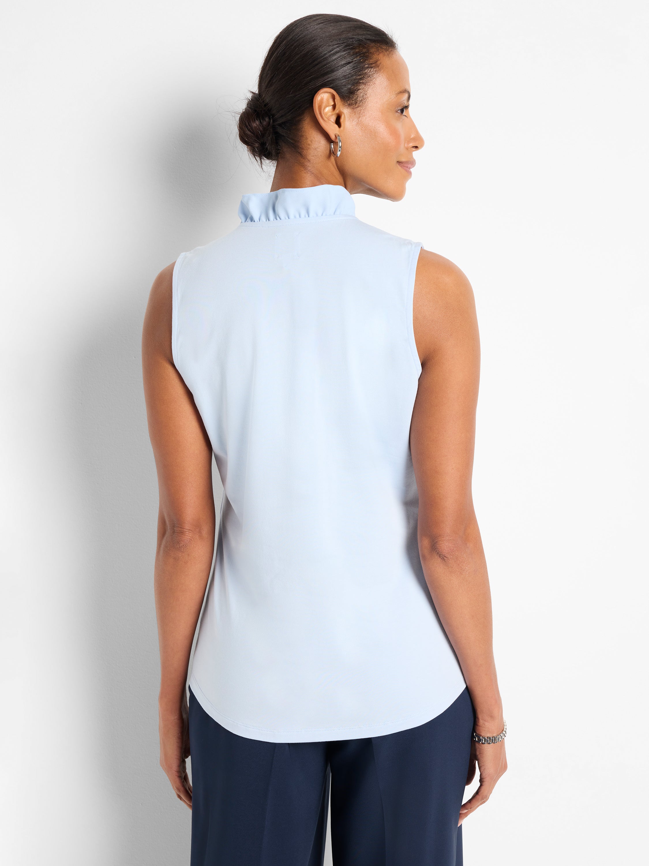 Light blue sleeveless shell top with a ruffled mock neck and relaxed fit.