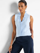 Light blue sleeveless tank with ruffled V-neckline and front buttons.