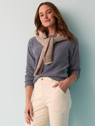 Navy blue and cream striped knit top, long sleeves.  Brown and cream knit scarf is styled around the neck.