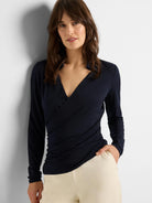 Dark navy collared knit wrap top with long sleeves, featuring a wrap-style front and V-neck.