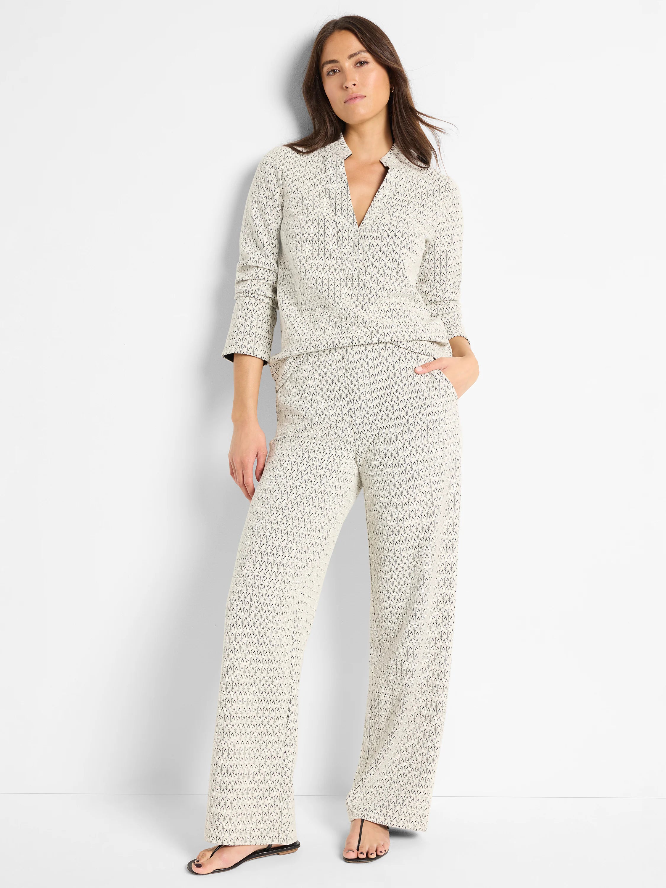 Off-white knit top with dark, repeating V-pattern, V-neck, and 3/4 sleeves.