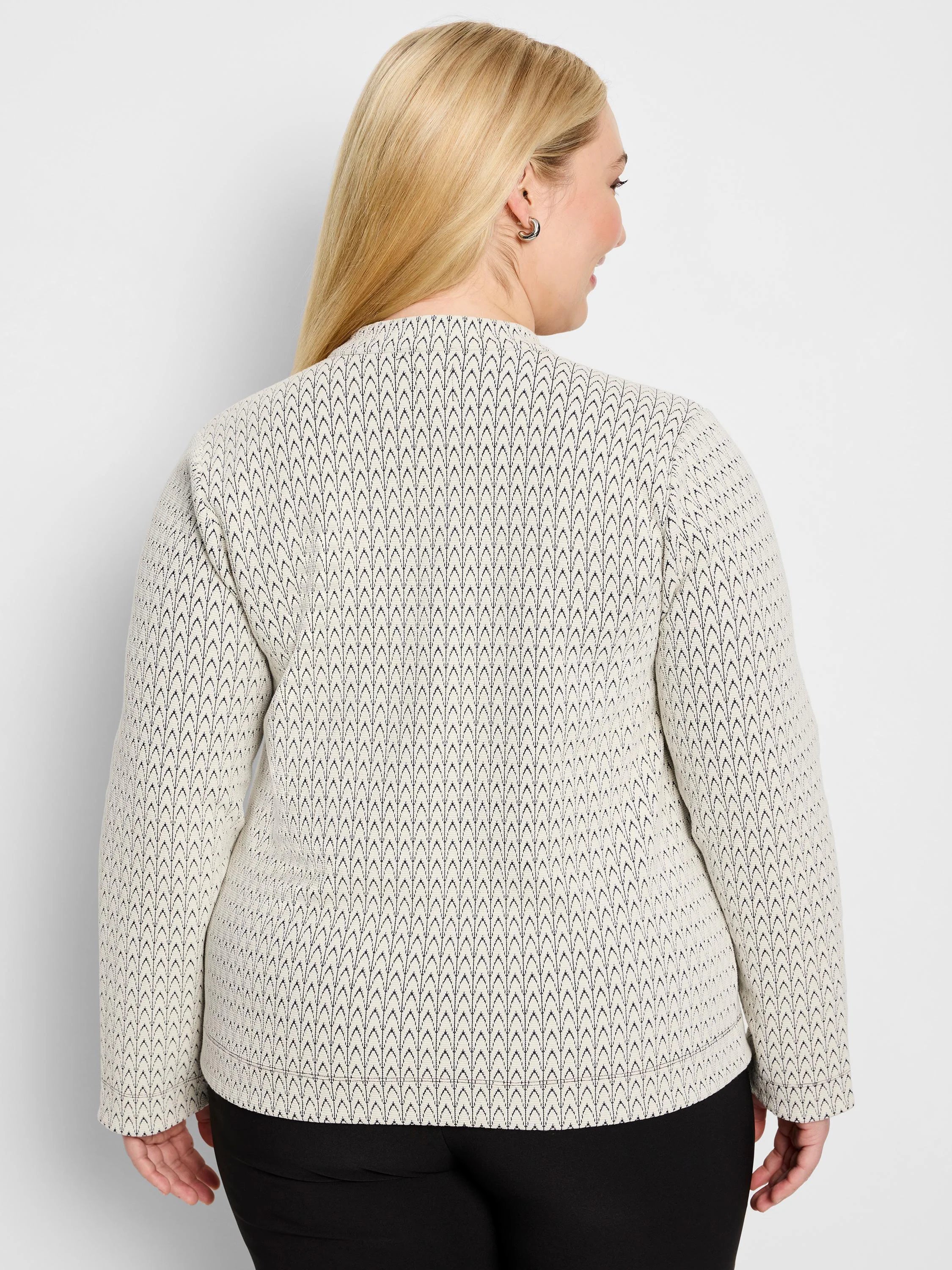 Off-white knit top with black chevron pattern, long sleeves, high neck. Model's back view.