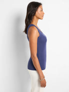 Model in profile wearing a blue ribbed knit scoop neck tank top.